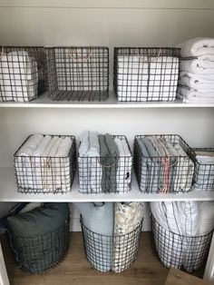 some baskets are stacked on top of each other in the closet, and one is filled with blankets