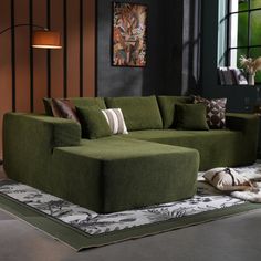 a green couch sitting on top of a rug in a living room