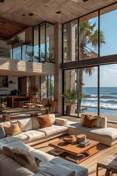 a living room filled with lots of furniture next to an ocean front window covered in windows