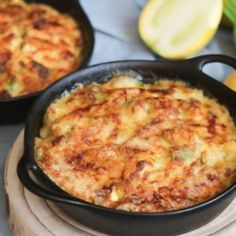 two black pans filled with food sitting on top of a table