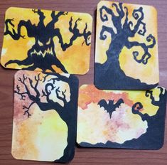 four square coasters decorated with bats and a tree on yellow, black and orange background