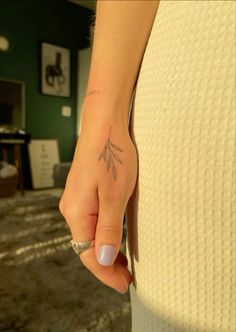 a woman's hand with a small tattoo on it