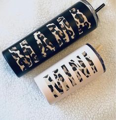 two black and white candles sitting next to each other on top of a towel covered floor