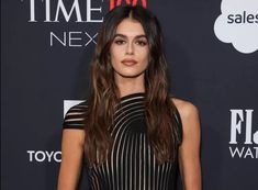 a woman with long hair wearing a black and white dress at the time 100 next event