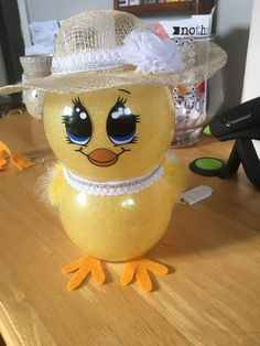 a yellow duck wearing a straw hat on top of a table