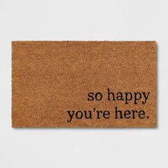 a cork door mat that says, so happy you're here