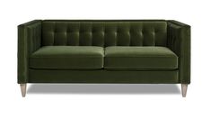 a green velvet couch with wooden legs