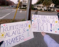 two people holding up signs in front of a street