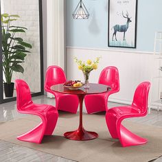 a dining room with pink chairs and a round table