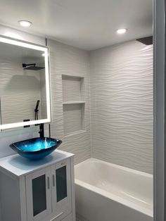 a bathroom with a sink, mirror and bathtub in it's own area