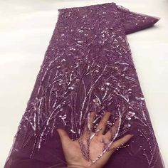 a woman's hand is on the purple fabric