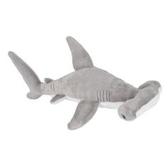 a stuffed shark is laying down on the white ground with it's mouth open