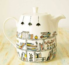 a tea pot with books on it sitting on a table