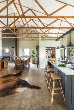 an open kitchen and dining area with wooden beams