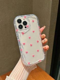 a person holding up a phone case with hearts on it