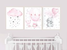 two pink and gray nursery art prints on the wall above a crib