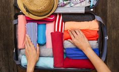 an open suitcase filled with clothes and hats