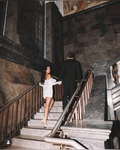 a man and woman are walking down the stairs