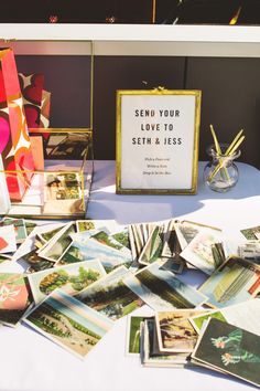 a table topped with lots of cards and pictures next to a sign that says send your love to seith & jess