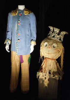 two mannequins dressed in costumes with hats and scarves