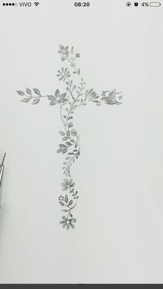 a drawing of a cross with flowers and leaves on it, next to a pair of scissors