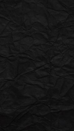 a black paper textured background that is slightly wrinkled out and has been used as a backdrop