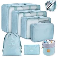 four pieces of blue luggage with white lettering on them and one bag filled with toiletries