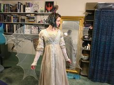 a woman dressed as a fairy standing in front of a mirror wearing an elaborate costume