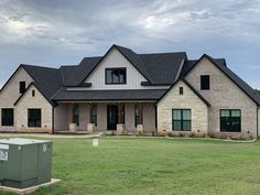 a large brick house with black roof and windows