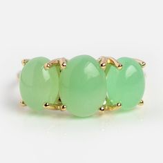 three green jade stone rings with gold posts on each side, set against a white background