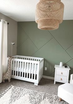 a baby's room with a white crib and green walls