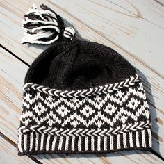 a black and white knitted hat with tassels