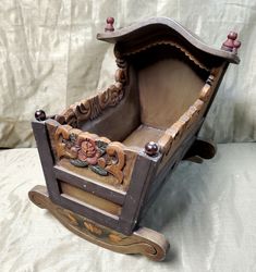 an old wooden rocking chair with floral decorations on the back and sides, sitting on a white sheet