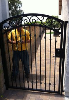 a man standing in front of a black gate