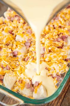 a casserole dish with ham and cheese being poured into it