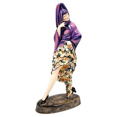 a figurine of a woman wearing a purple jacket and skirt with her legs crossed