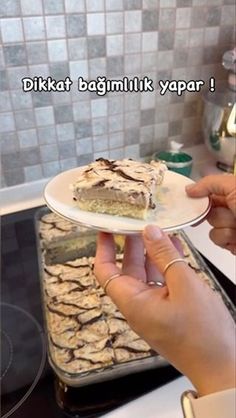 a person holding a plate with food on it in front of a stove top oven