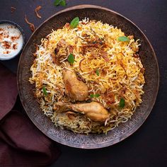 an overhead view of a plate of food with chicken and rice on it, next to a bowl of yogurt