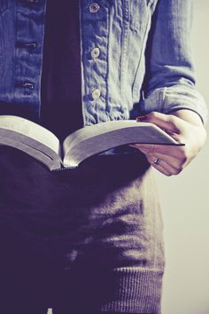 a person holding an open book in their hands