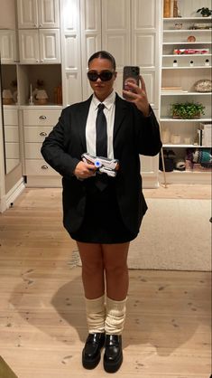 a man in a suit and tie taking a selfie with his cell phone while wearing socks