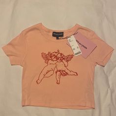 New Girl Order Graphic Cherub Tee (Light Pink/ Peachy With Red Print) Purchased From Urban Outfitters Size Small Nwt! Never Worn. Urban Outfitters Graphic Tee For Summer, Urban Outfitters Graphic Print Summer Top, Spring Urban Outfitters Graphic Tee, Urban Outfitters Letter Print Tops For Spring, Basic Pink Tops With Graphic Print, Urban Outfitters Pink Crew Neck Top, Trendy Pink Tops From Urban Outfitters, Pink Urban Outfitters Tops For Summer, Trendy Pink Urban Outfitters Tops