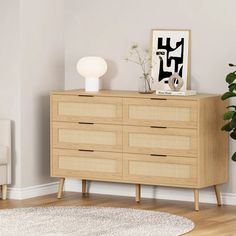 a wooden dresser sitting in a living room next to a white chair and potted plant