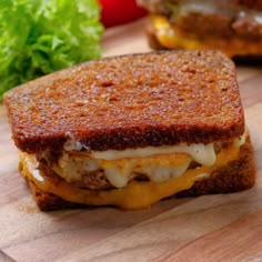 a grilled cheese sandwich sitting on top of a wooden cutting board