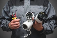 a man holding three different cameras and pliers