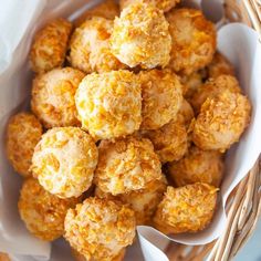 a basket filled with fried food sitting on top of a white tablecloth next to a red and white checkered napkin