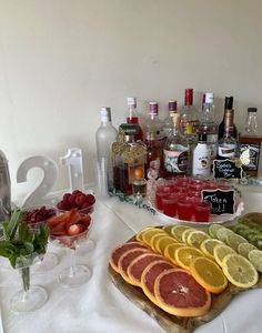 a table topped with lots of different types of drinks and fruit on top of it