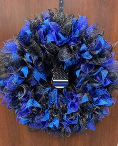 a blue and black wreath hanging on the front door with a guitar shaped decoration attached to it