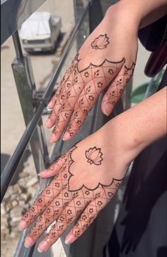 two hands with hendi tattoos on them, one is holding the other's hand