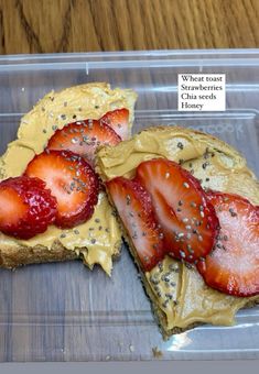 two slices of toast with strawberries on top and sesame seeds on the side, sitting in a plastic container