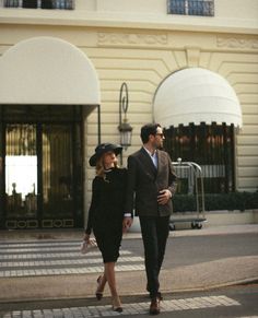 a man and woman are walking down the street